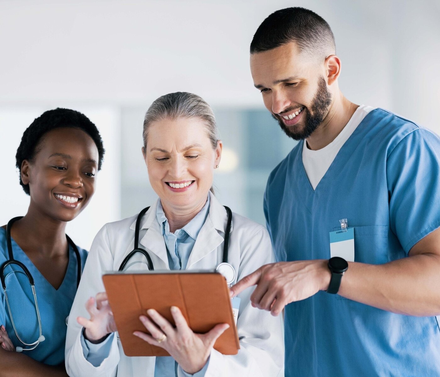 Diversi medici guardano un iPad e ridono.