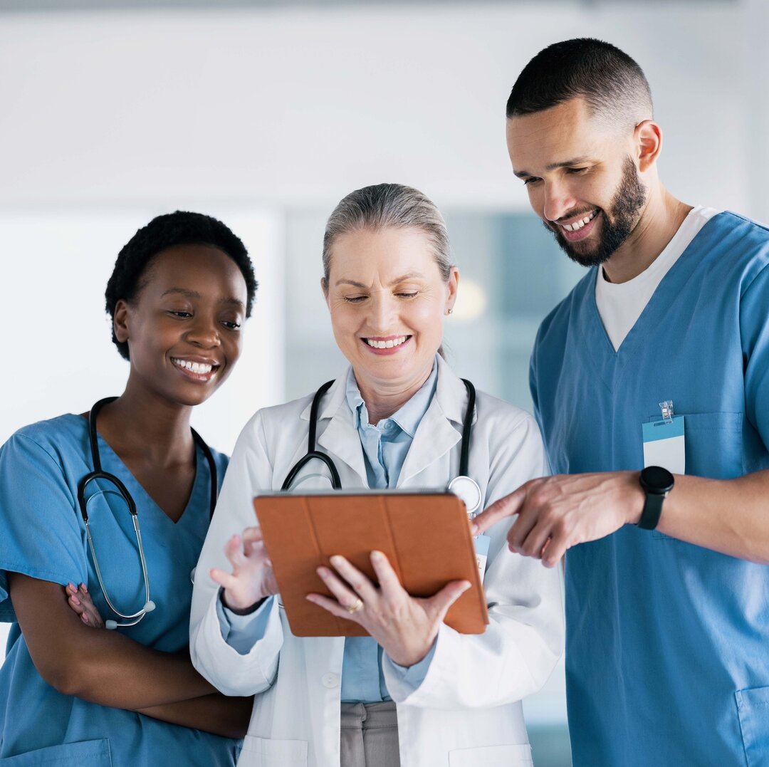 Ärztinnen und Arzt schauen glücklich aufs Tablet