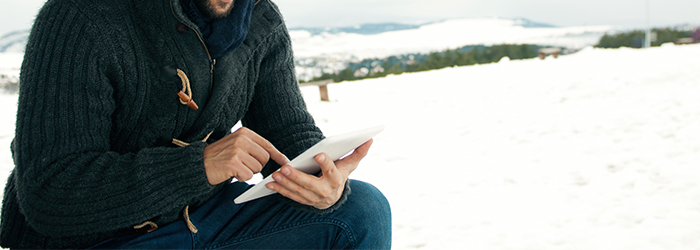 Mann mit Tablet im Schnee